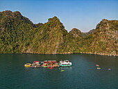  Aerial view of sea kayaks and cruise ship transfer boats at a pontoon with mountains in the background, Lan Ha Bay, Haiphong, Vietnam, Asia 