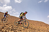 Mountain bikers with electric assistance off the road from Zagora to the south (N 9), Draa River valley, Province of Zagora, Region Draa-Tafilalet, Morocco, North West Africa