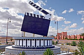 Monument to the glory of cinema on a roundabout near CLA Movie Studios (background), Ouarzazate, Ouarzazate Province, region of Draa-Tafilalet, Morocco, North West Africa