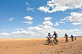 Riders on mountain bike with electric assistance on a track between Ouarzazate and Ait Ben Haddou, Ounila River valley, Ouarzazate Province, region of Draa-Tafilalet, Morocco, North West Africa