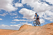 Rider on mountain bike with electric assistance on a track between Ouarzazate and Ait Ben Haddou, Ounila River valley, Ouarzazate Province, region of Draa-Tafilalet, Morocco, North West Africa