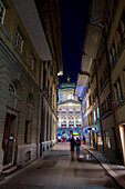 Beautiful Bundeshaus Illuminated Parliament Building or Federal Palace and a Street with People at Night in City of Bern, Bern Canton, Switzerland.