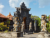 Intricately carved stone guardian statues at Batu Mejan Temple (Pura Batu Mejan). Tanah Lot, Bali, Indonesia.