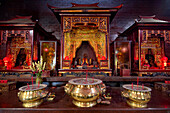 Golden incense urns on the table in front of the altar in Vihara Dharmayana, the 19th century Buddhist temple in Kuta, Bali, Indonesia.