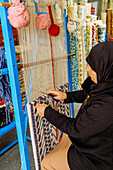  Woman weaving carpets in a carpet shop in the Medina of Hammamet, Tunisia 