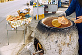  Traditional production of Berber bread (Tabouna, Khobz Tabouna) in an open, wood-fired clay oven (clay pot) in El Metbassta in the Kairouan Governorate, Tunisia 
