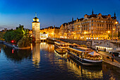  Hotel boats on the Vltava river bank and Sitkov Water Tower at dusk, Prague, Czech Republic 