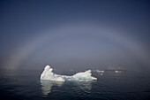  A fog bow stretches over an iceberg in the Vikingebugt, Arctic Greenland, Europe 