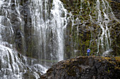 Wanderer auf Felsen vor Wasserfall, Dynjandi, Island, Nordeuropa, Europa