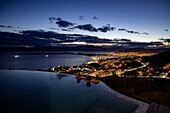  Couple relaxing in the infinity whirlpool of the Arakur Ushuaia Resort and Spa overlooking the city lights at dusk, Ushuaia, Tierra del Fuego, Patagonia, Argentina, South America 