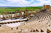  Theater with columns of the stage, tiers and view, ruins of ancient Thugga at the archaeological site near Dougga, Tunisia 
