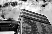 Industriegebäude von unten gegen Wolkenhimmel, Fenster und Betonfassade, Zeche Zollverein Essen, Deutschland