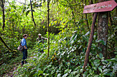 Tourist woman and a guide on a track in Obo Natural Park,Sao Tome Island, Republic of Sao Tome and Principe,Africa