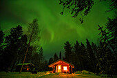 Wooden cabin, Northern lights and Milky Way, Lapland, Finland, Arctic Circle