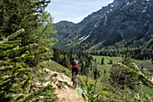  Mountain bikers on the Staufenrunde, Chiemgau Alps, Bavaria, Germany 