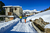 Zwei Personen wandern an Almhütten vorbei zum Rifugio Saoseo, Val da Camp, Livignoalpen, Graubünden, Schweiz
