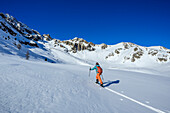  Woman on ski tour ascending to Passo Confine, Saoseo Group in the background, Passo Confine, Val da Camp, Livigno Alps, Graubünden, Switzerland 