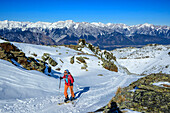  Woman on ski tour ascending the slope to the Glungezer, Karwendel in the background, Glungezer, Tux Alps, Tyrol, Austria 