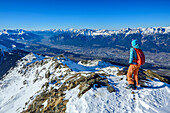  Woman on ski tour looking down at the Inn Valley from the Sonnenspitze, Sonnenspitze, Glungezer, Tux Alps, Tyrol, Austria 