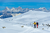  Two people on ski tour ascending to the Kleiner Pleißlingkeil, Dachstein in the background, Kleiner Pleißlingkeil, Niedere Tauern, Salzburg, Austria 