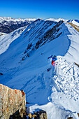  Man on ski tour skis into steep cirque, Felskarspitze, Niedere Tauern, Salzburg, Austria 