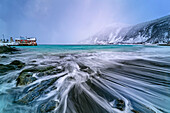  Wild sea surf with lighthouse and fisherman&#39;s hut on the beach, Bovaer, Senja, Troms, Norway 