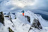  Woman climbing the summit ridge of Husfjell, Husfjell, Senja, Troms, Norway 