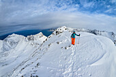  Woman climbing the summit ridge of Husfjell, Husfjell, Senja, Troms, Norway 