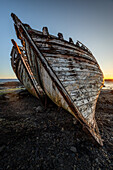  Wooden shipwrecks lie on dry land on the shore. Frontal view. 