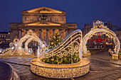 Brightly illuminated festive Christmas decorations in front of Bolshoi Theater in the historic center of Moscow, Russia.
