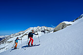  Two people on ski tour ascending to the Rosskarscharte, Zillertal Alps, Salzburg, Austria 