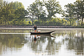Agnes bringing , in electric boat, the breakfast to a Floating cabin of Clos de la Loutre (Otter's cottage), Etang de Bornacq, Loye-sur-Arnon, Cher department, Historic Province of Berry, Centre-Valde Loire region,
