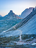 Wanderweg östlich der Drei Zinnen am Paternsattel mit Blick auf die Dreizinnenhütte kurz vor dem Sonnenaufgang, Drei Zinnen, Auronzo di Cadore, Belluno, Venetien, Toblach, Bozen, Trentino, Südtirol, Italien, Sextner Dolomiten, Alpen, Dolomiten, Südeuropa, Europa