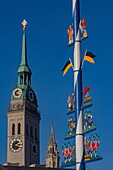  Maypole with figural decorations at the Viktualienmarkt, behind it the tower of St. Peter&#39;s Church and the New Town Hall, Munich, Bavaria, Germany 