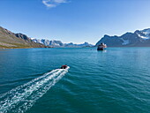  Aerial view of the expedition cruise ship World Voyager (Atlas Ocean Voyages) with Zodiac inflatable boat, Niaqornaq Bay, Queqatta, Greenland, Europe 