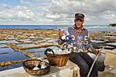 Salt man worker selling salt by the salt pans on the north coast of Gozo Island, Malta, Mediterranean Sea,  Southern Europe