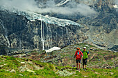 Mann und Frau beim Wandern mit Fellariagletscher im Hintergrund, Valmalenco, Alta via della Valmalenco, Bernina-Alpen, Lombardei, Italien