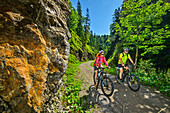 Mann und Frau beim Mountainbiken fahren durch enge Schlucht, Rund um die Rotwand, Bayrischzell, Mangfallgebirge, Bayerische Alpen Oberbayern, Bayern, Deutschland