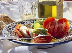 Tomatoes with mozzarella & basil; decoration: olive oil