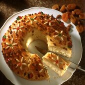 Yeast wreath with candied fruit pieces, a piece cut