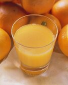 Orange Juice with Oranges in Background