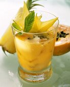 Papaya-Ananas-Drink, garniert mit Karambolesternen & Minze