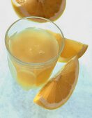 Glass of grapefruit juice and yellow grapefruit wedge