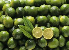 Many limes, one halved on top (close-up)