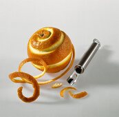 Orangenschale spiralförmig mit Schäler geschnitten