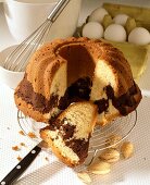 Marble cake with almonds on cake rack, ingredients behind