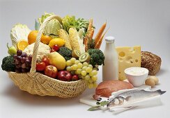 Korb mit Obst und Gemüse, daneben Fisch, Kalbfleisch etc.