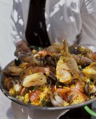 Person holding mixed paella
