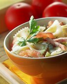 Nudelsalat mit Tomaten und Schinkenstreifen im Schälchen