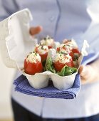 Tomatoes stuffed with crab salad, served in egg box